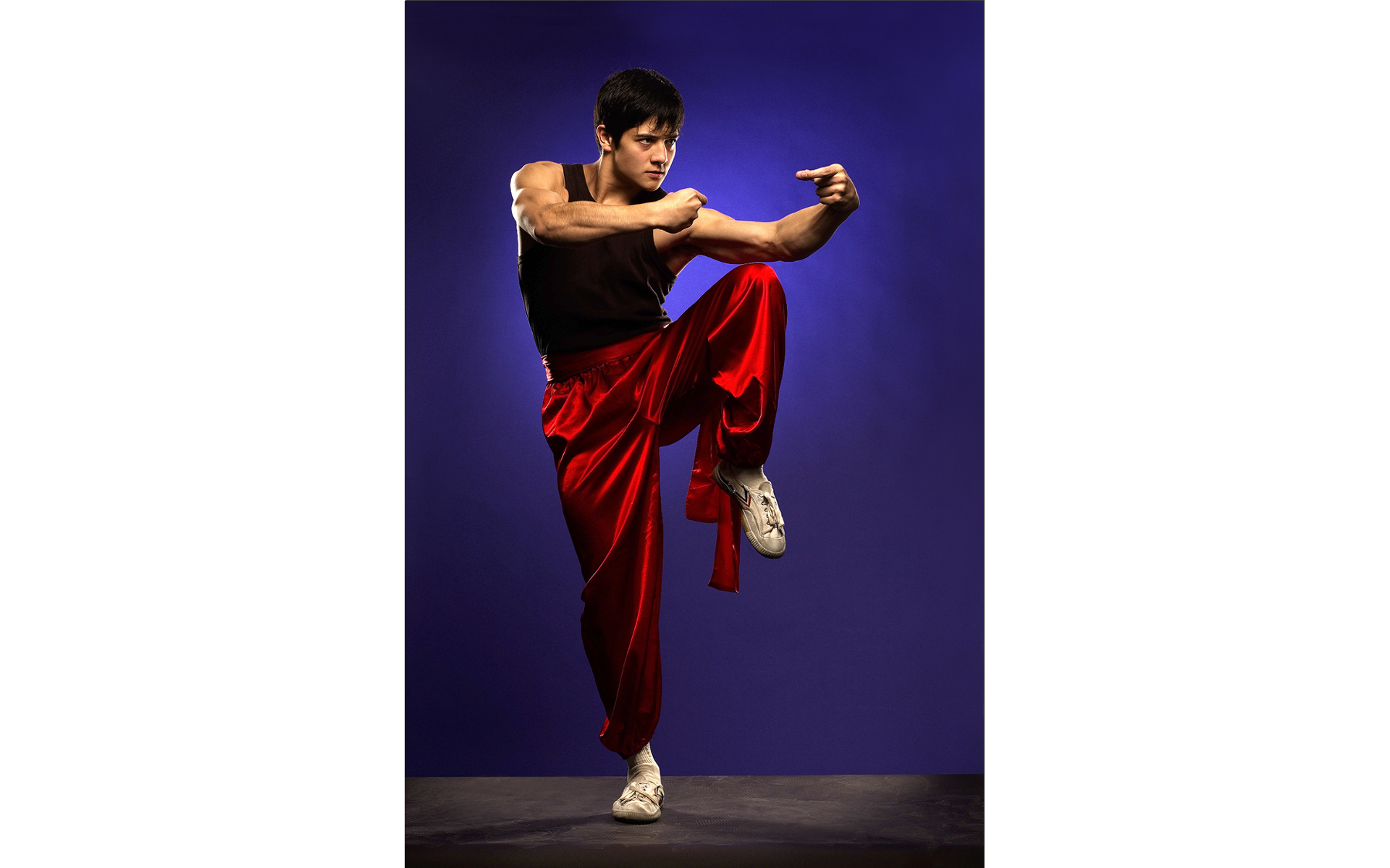kung fu actor in red front of blue backdrop photo shoot London